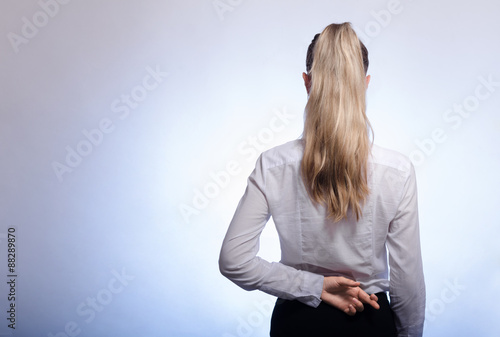 Young boss fingers crossed behind his back