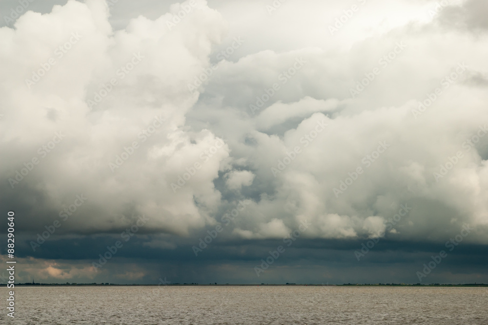 Cloudscape of ominous storm and rain clouds, so called cumulonimbus over Waddensea, Netherlands Cloudscape of ominous storm and rain clouds, so called cumulonimbus over Waddensea, Netherlands