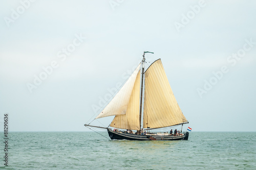 Traditional old Dutch wooden sailboat sailing on Waddensea, Netherlands