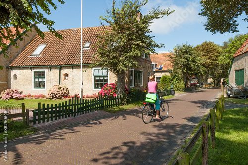 Street scene with woman on bicycle in  historical town Hollum on West Frisian island Ameland, Netherlands photo
