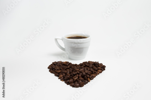 Cup coffee on a Heart shape made from coffee on white background