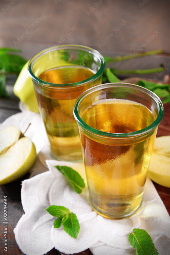 Glasses of apple juice on wooden table, closeup Glasses of apple juice on wooden table, closeup