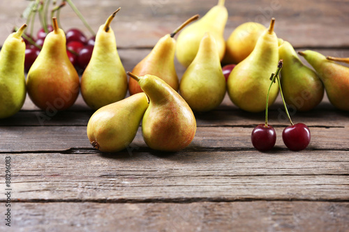 Ripe pears and cherries on wooden table close up