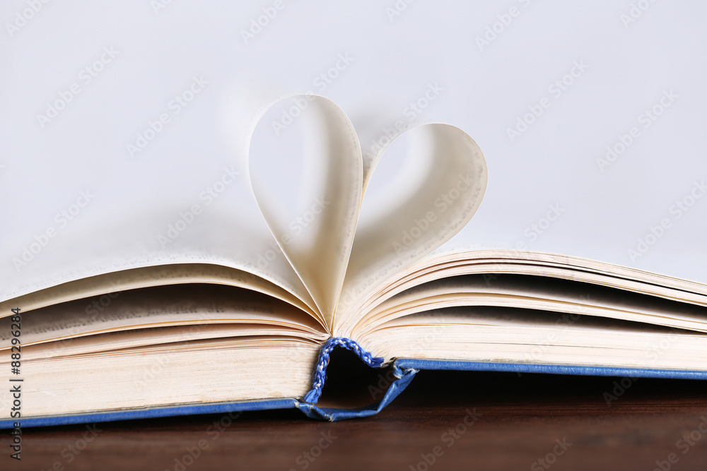 Pages of book curved into heart shape, close up Pages of book curved into heart shape, close up