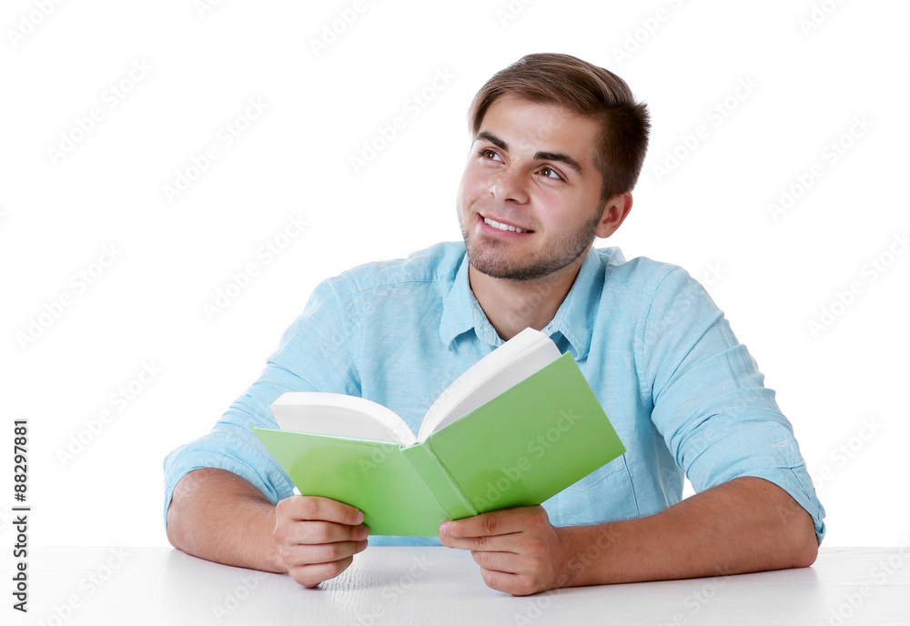 Young man reading book at table on white background Young man reading book at table on white background