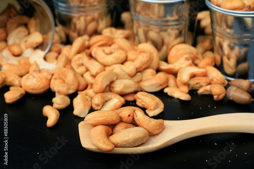 heap cashew nuts and salt on black background