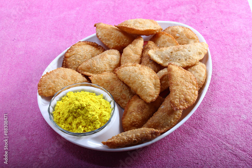 gujia in plate with holi color in bowl photo