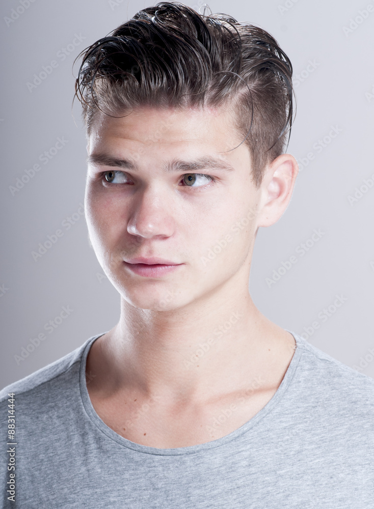 Handsome young man with fashion hairstyle over gray background. Handsome young man with fashion hairstyle over gray background.