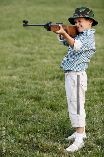 little boy with airgun outdoors