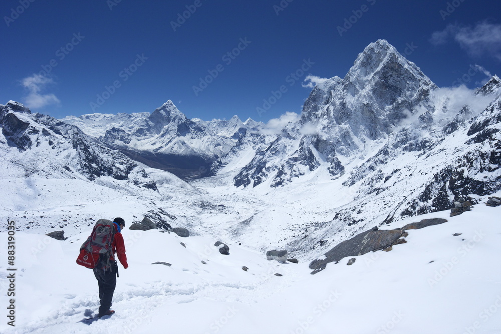 Sherpa guide walking over Cho La Pass with Ama Dablam on left and Arakam Tse on right side, Solukhumbu District, Nepal, Himalayas Sherpa guide walking over Cho La Pass with Ama Dablam on left and Arakam Tse on right side, Solukhumbu District, Nepal, Himalayas
