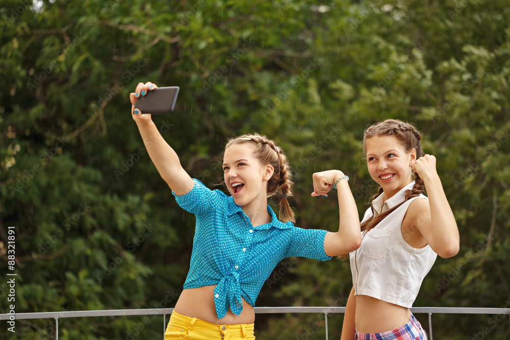 Obraz premium Best girlfriends are photographed in park. Photo phone selfie.