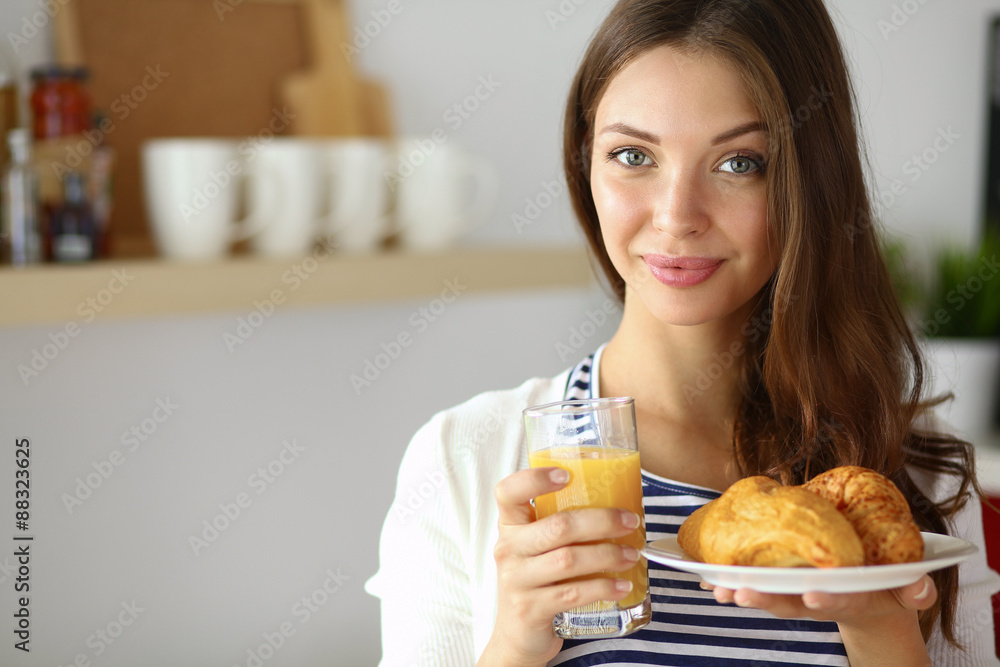 Young woman with glass of juice and cakes