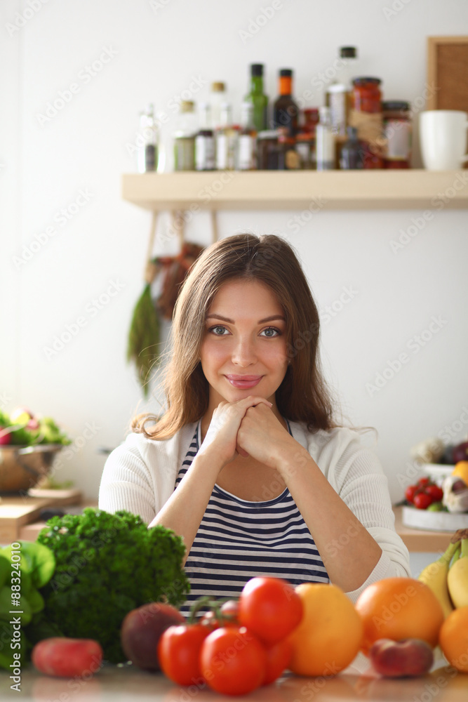 Young woman standing near desk in the kitchen Young woman standing near desk in the kitchen