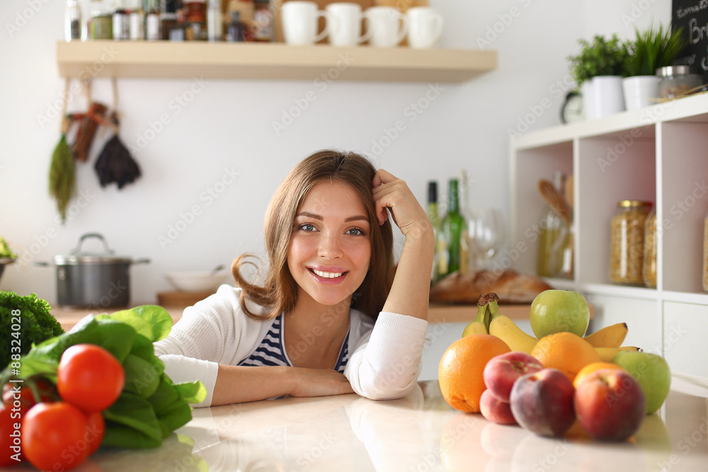Young woman standing near desk in the kitchen Young woman standing near desk in the kitchen