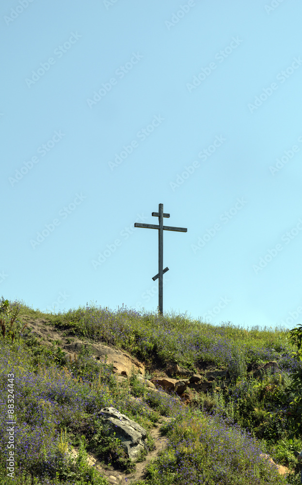 Big old wooden cross on a hill on a clear blue cloudless sky Big old wooden cross on a hill on a clear blue cloudless sky