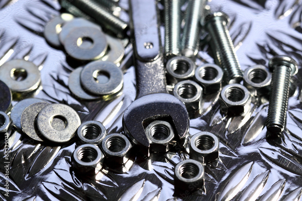 Nuts bolts washers spanner.
Various nuts bolts washers and a spanner on a steel background.