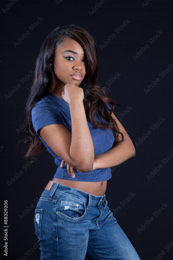 Thoughtful black woman in blue jeans Thoughtful black woman in blue jeans