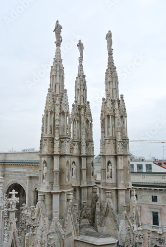 Architectural details from the roof of Milan Cathedral (Duomo di Milano) built in Gothic style, in white marble.