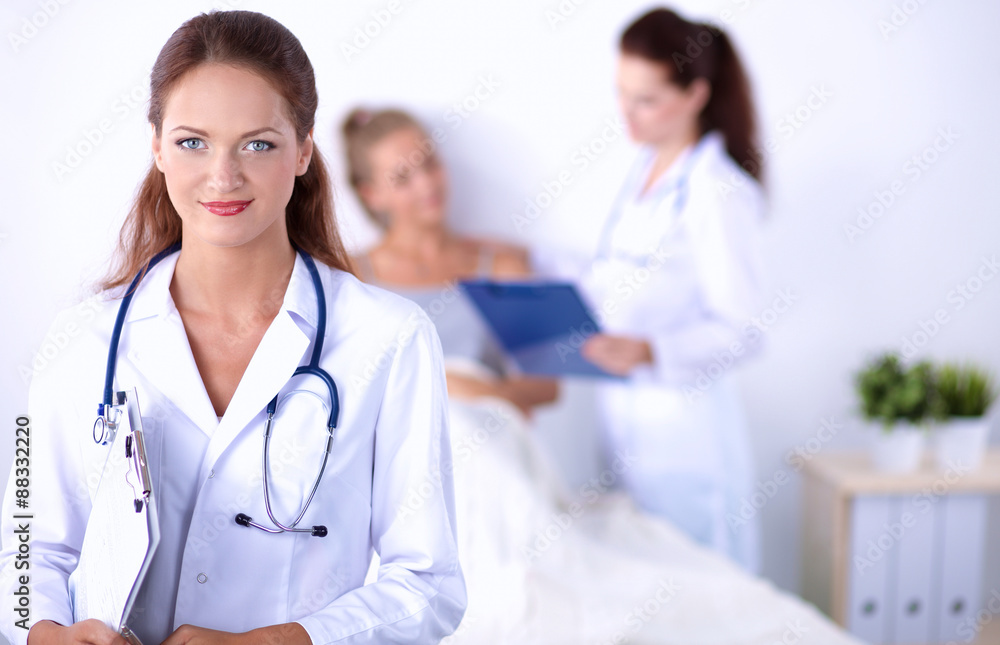 Smiling female doctor with a folder in uniform standing at Smiling female doctor with a folder in uniform standing at