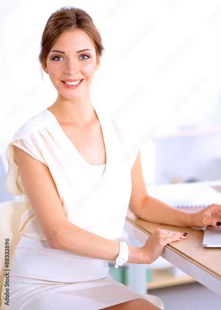 Portrait of a businesswoman sitting at desk with laptop Portrait of a businesswoman sitting at desk with laptop
