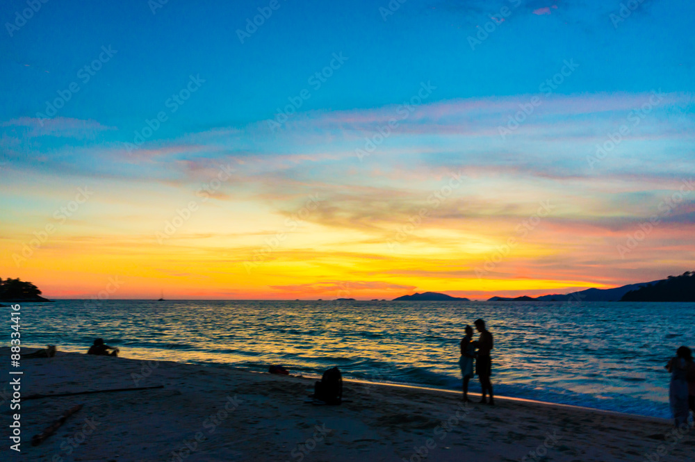 Silhouettes of a couple at beach in sunset