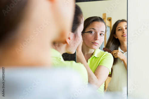 Teenage girlfriends having fun near mirror