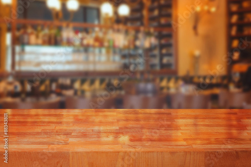 Wooden table over blurred bar interior