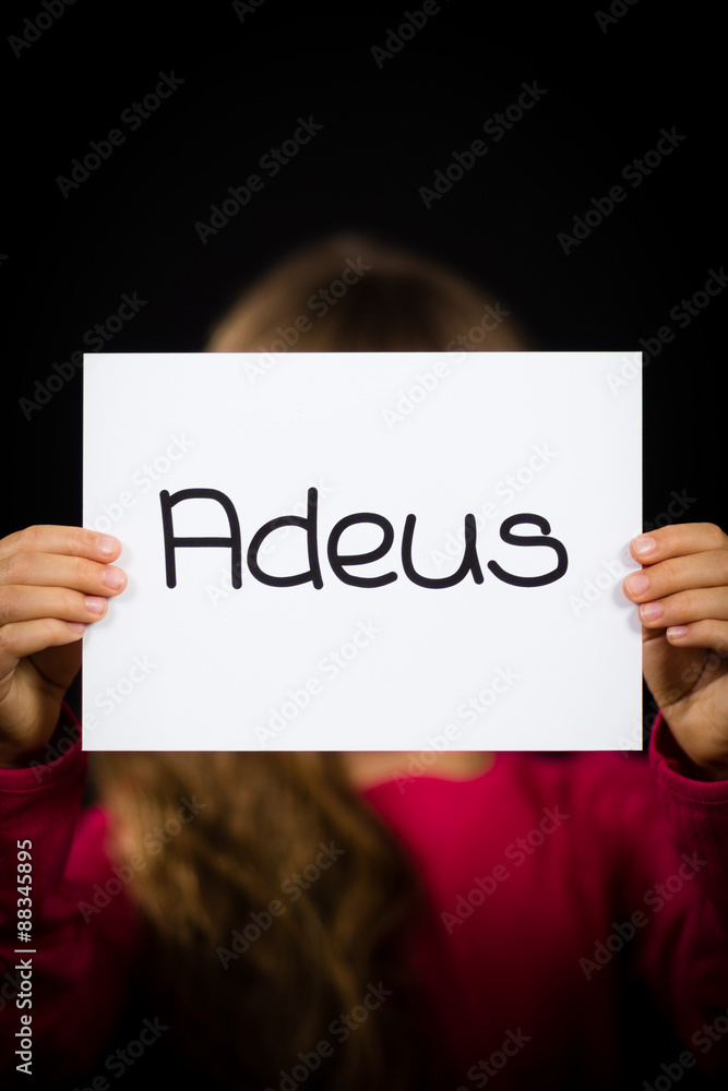 Child holding sign with Portuguese word Adeus - Goodbye Child holding sign with Portuguese word Adeus - Goodbye