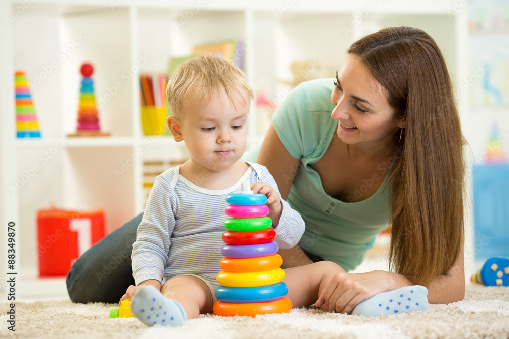 child and woman play together in nursery child and woman play together in nursery