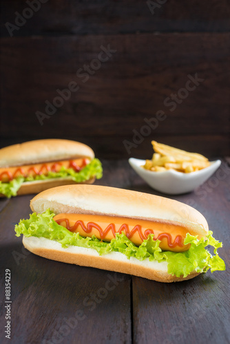 Hot dog with french fries on wooden table