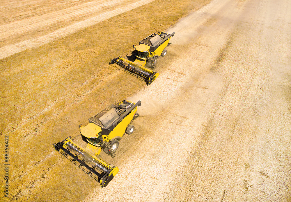 Aerial view of combine harvester working on wheat field. Industrial background on agricultural theme. Aerial view of combine harvester working on wheat field. Industrial background on agricultural theme.