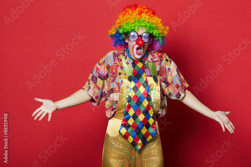 Photo funny clown with glasses on red
