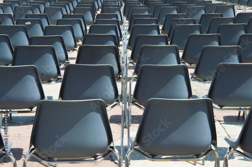 Dark-blue plastic chairs waiting for audience at an open-air event