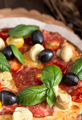 Pizza with salami and mushrooms closeup