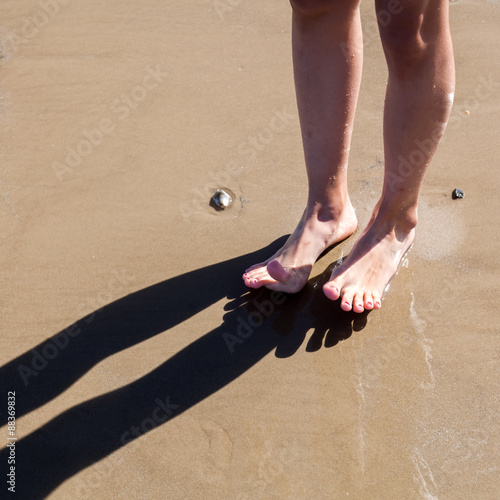 Füße eines jungen Mädchens am Sandstrand