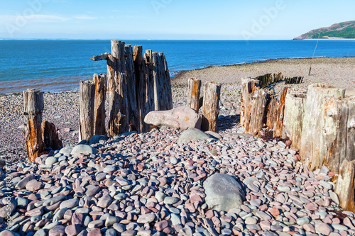 Holzpfähle einer Buhne in Porlock Weir, Somerset, England photo