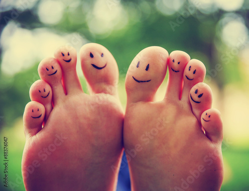smiley faces on a pair of feet on all ten toes (VERY SHALLOW DOF photo