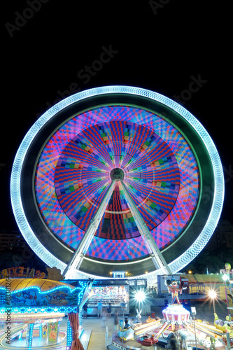 Colorful ferris wheel in motion at night