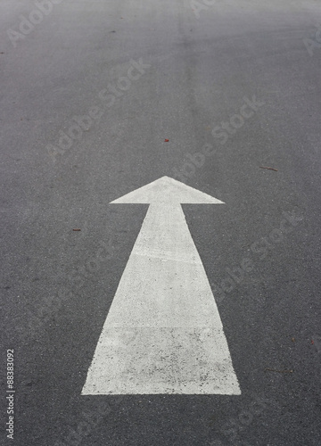 Arrow sign on asphalt surface