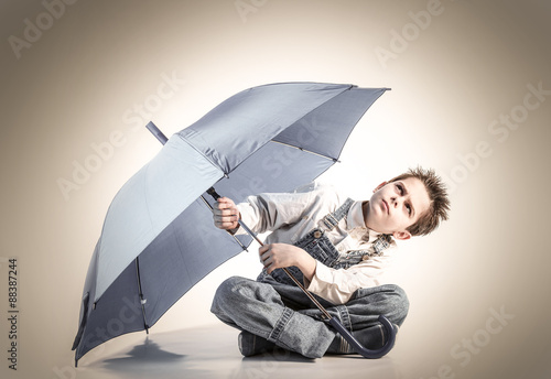 ragazzino preoccupato con ombrello photo