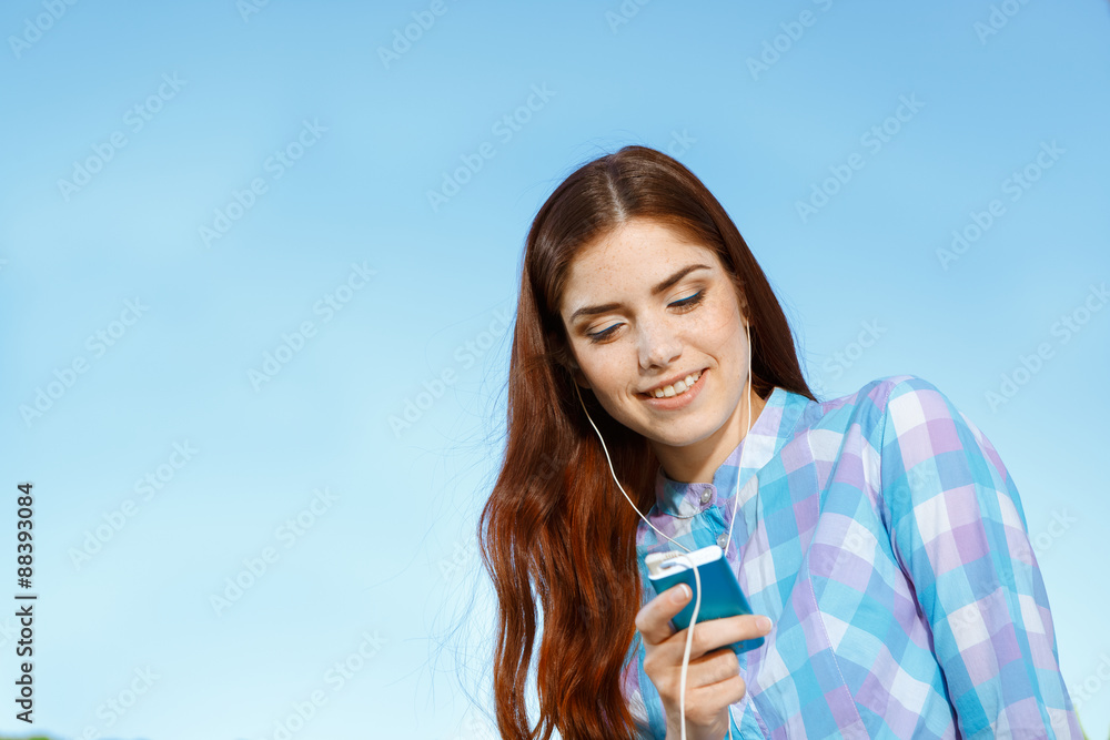 Beautiful girl in park with her phone