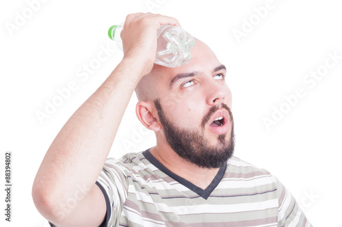 Fototapeta Man cooling his head with cold water in plastic bottle