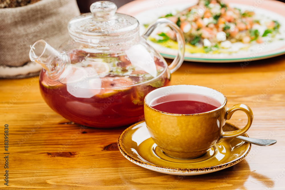 cup of tea and kettle on wooden background cup of tea and kettle on wooden background