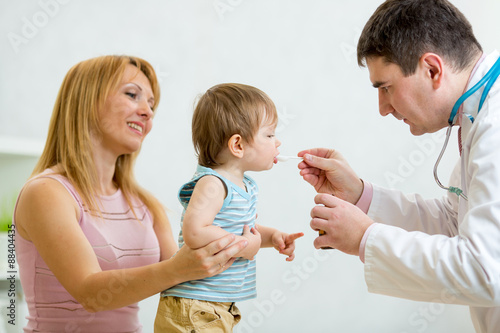 Doctor giving a spoon of sy...