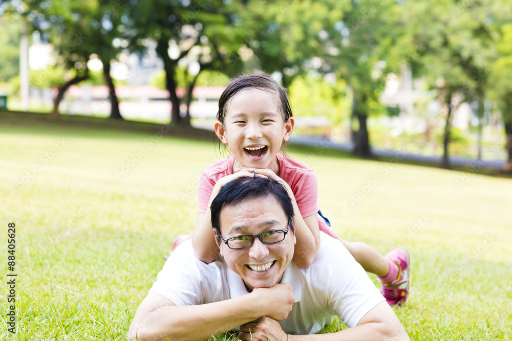 happy father and little girl lying on the grass happy father and little girl lying on the grass
