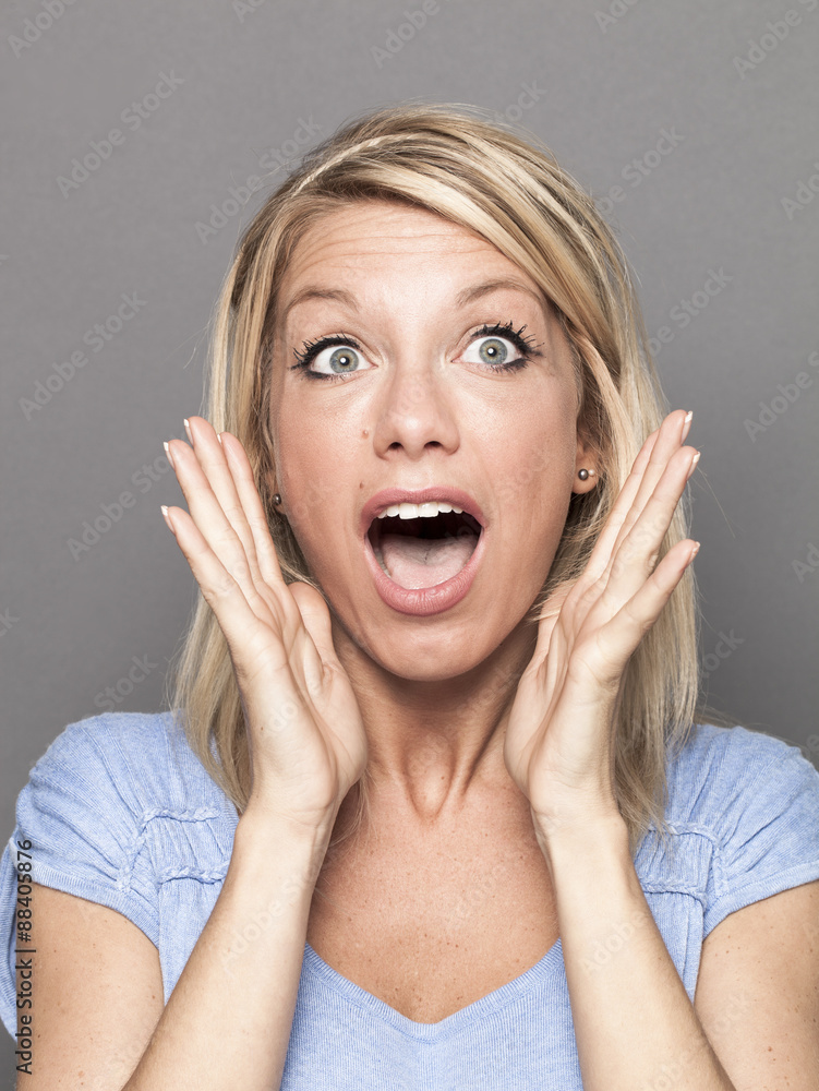 surprise and success concept - lovely 20s blonde woman using both hands and facial expression for surprise and happiness
