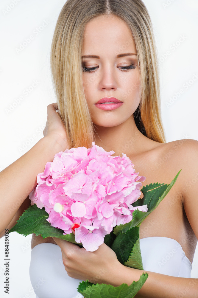 Closeup portrait of beautiful young woman with natural makeup with pink flower, isolated on white background