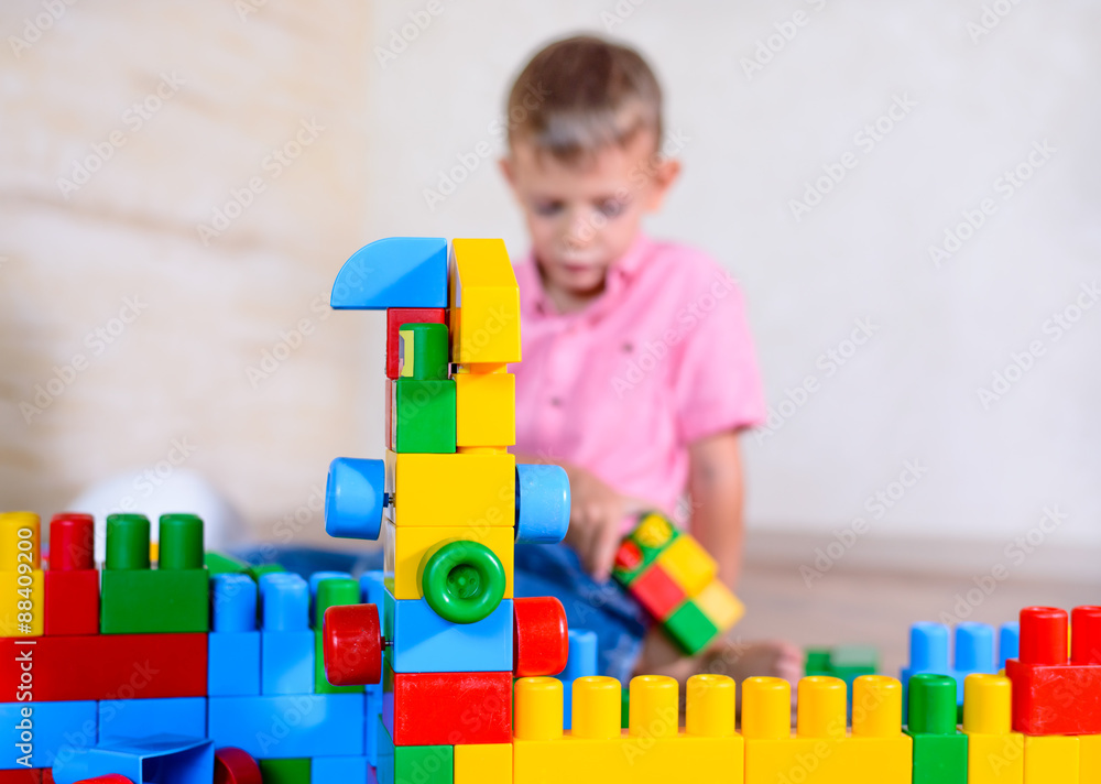 Happy young boy playing with his building blocks Happy young boy playing with his building blocks