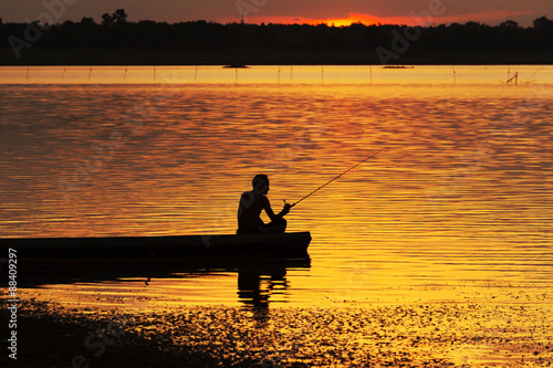 Silhouette Fishermen fishing on a boat