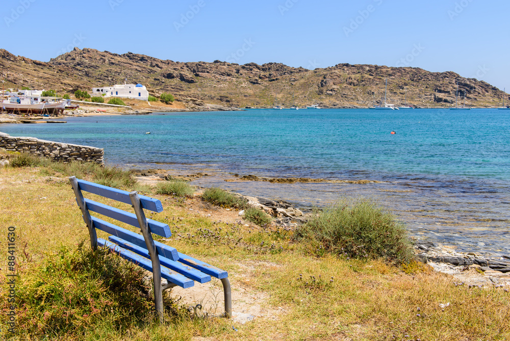 Bench on the beach with crystal clear water, environmental and cultural park of Paros island, Cyclades, Greece.